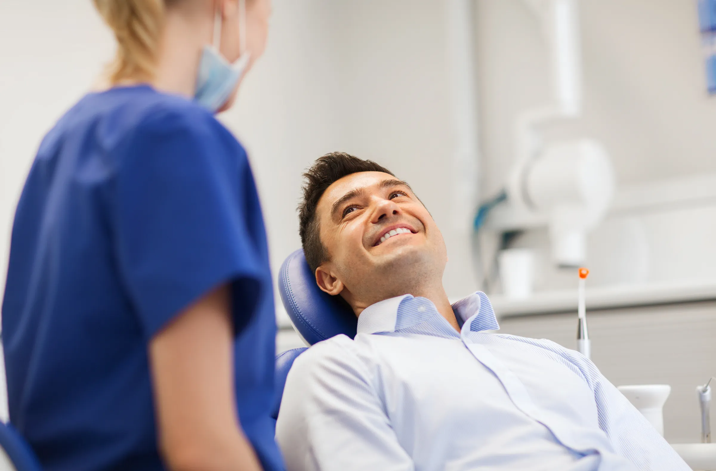 A patient in the dental chair talking with a hygienist during a check-up