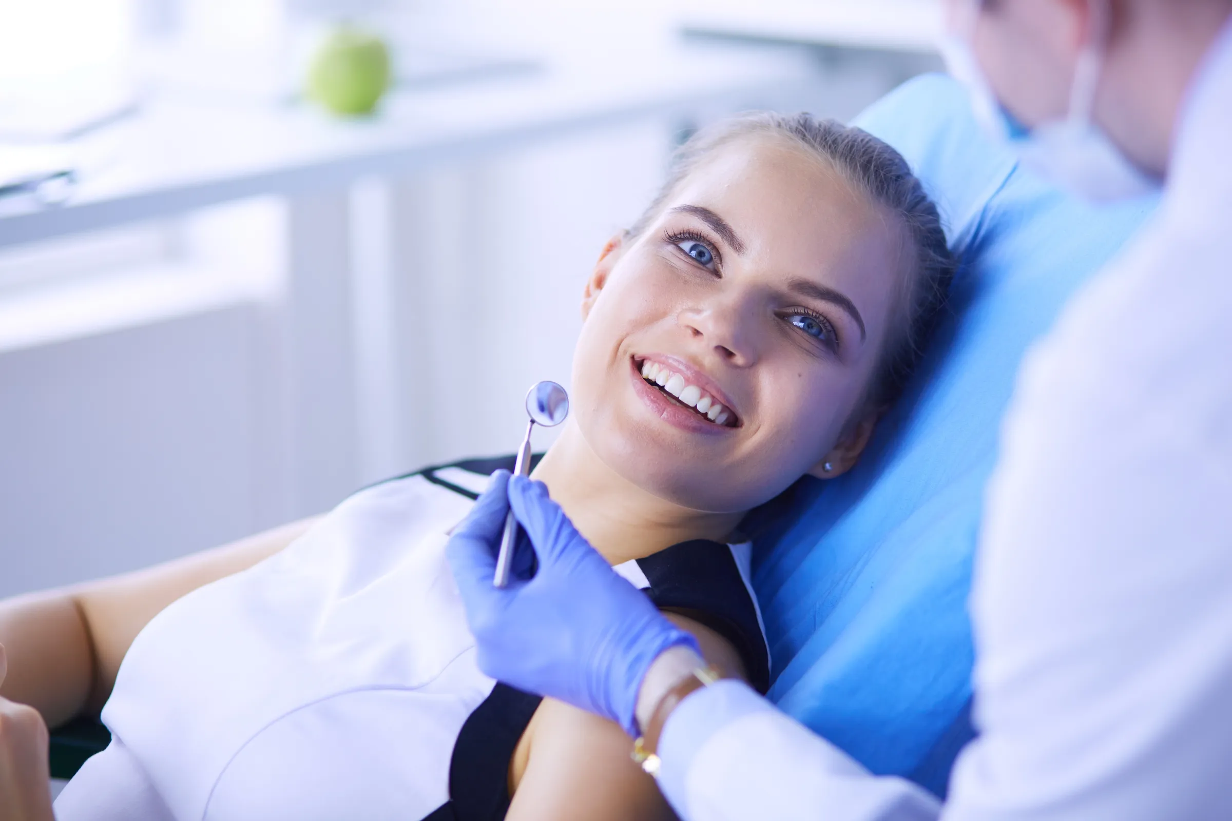 A patient smiling during an examination in the dental chair