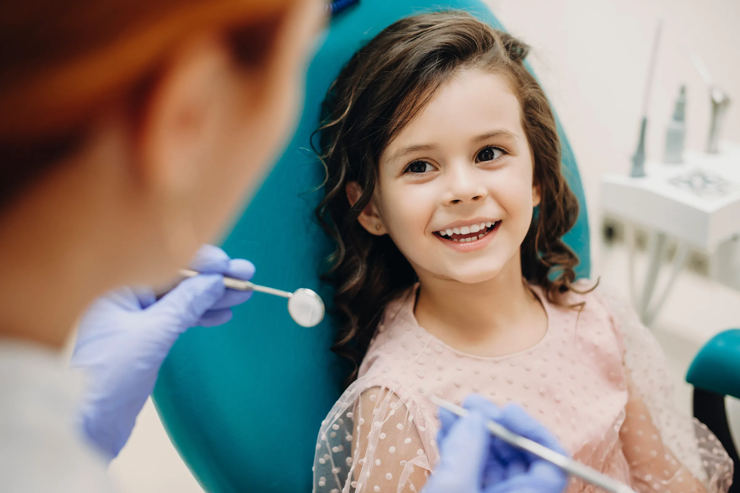 A young girl smiling in the dental chair during a check-up