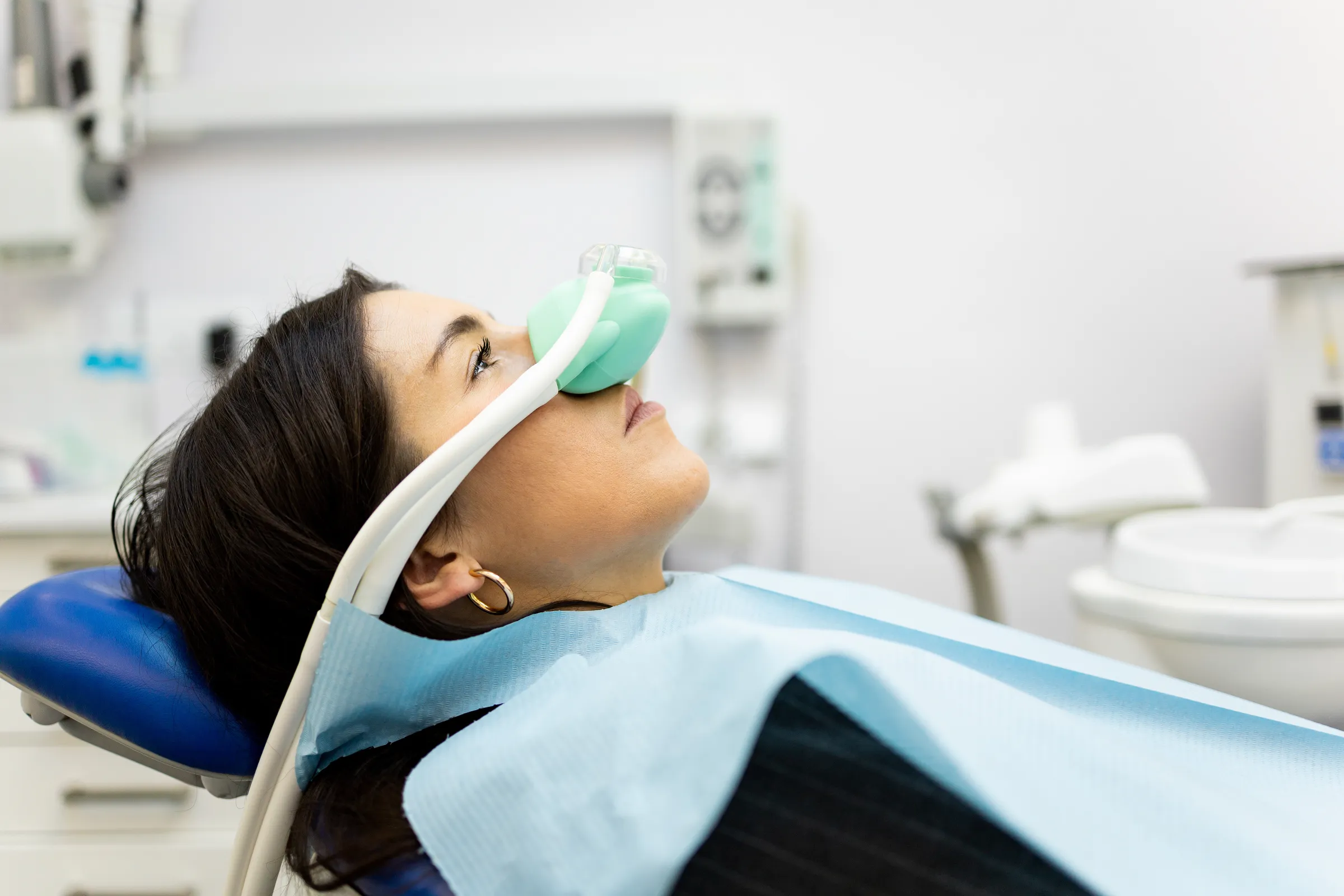 A patient reclining with a sedation mask over her nose