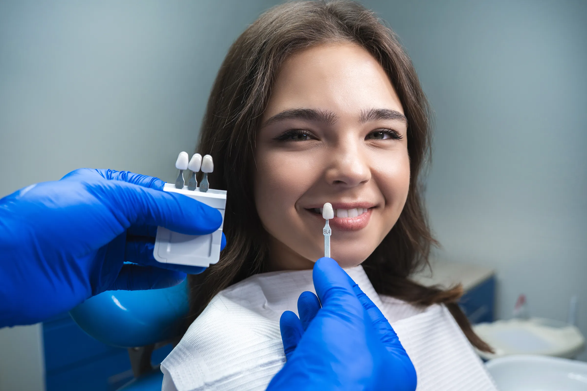 A shade tab held to a patient's teeth during a veneer consultation