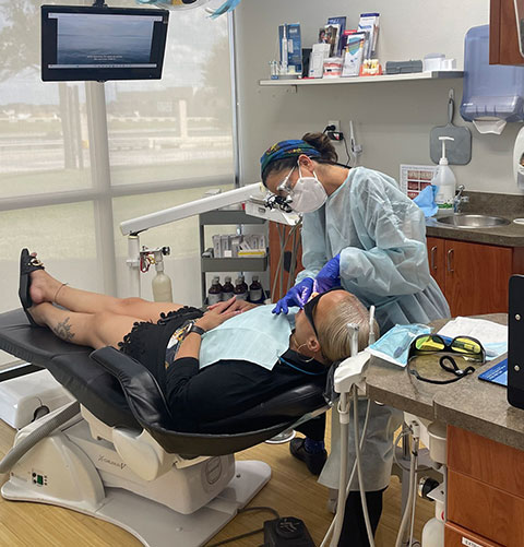 A clinician treating a patient in one of the practice's treatment rooms
